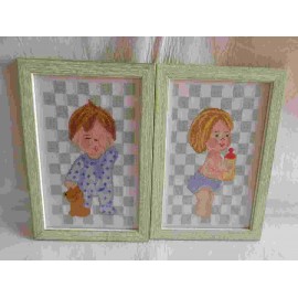Pareja de cuadros enmarcados realizados a punto de cruz de niño y niña para habitación infantil.