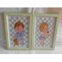 Pareja de cuadros enmarcados realizados a punto de cruz de niño y niña para habitación infantil.