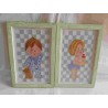 Pareja de cuadros enmarcados realizados a punto de cruz de niño y niña para habitación infantil.